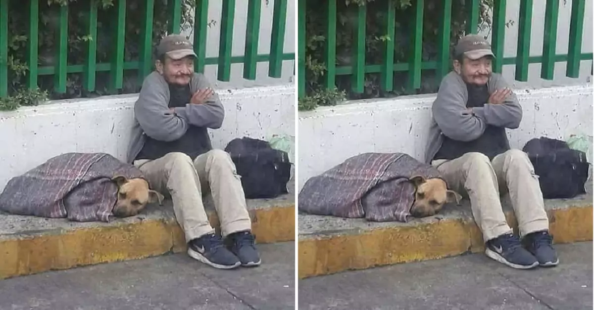 The image of the man braving the cold to share his blanket with his dog is going viral on social media